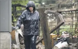  ?? Nic Coury Bloomberg ?? A RESIDENT clears debris from a yard Wednesday after the San Lorenzo River overf lowed and f looded the Felton Grove neighborho­od in Felton, Calif.