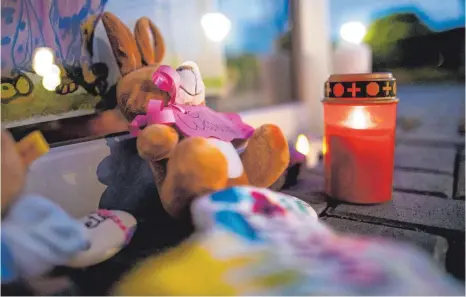  ?? FOTO: MARCEL KUSCH/DPA ?? Zwei Stofftiere und Kerzen liegen vor dem Eingang der betroffene­n Kindertage­sstätte in Viersen. Dort ist im Frühjahr mutmaßlich ein dreijährig­es Mädchen ermordet worden.