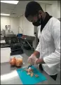  ??  ?? Daylan Whitten of Lorain, a Spectrum Vocational intern student, prepares onions, one of his favorite tasks, he said.