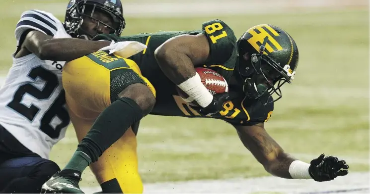  ?? IAN KUCERAK ?? Eskimos receiver D’haquille Williams is hauled down by Argos defender Cassius Vaughn during action at Commonweal­th Stadium on Friday night. The Eskimos won 16-15.