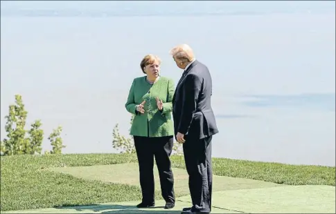  ?? YVES HERMAN / REUTERS ?? Ángela Merkel y Donald Trump conversan durante una pausa en la reunión del G-7 en Canadá, el pasado día 8