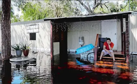  ?? DAVID GOLDMAN/AP PHOTO ?? Jose Lopez sits outside his flooded home while retrieving belongings in the aftermath of Hurricane Irma in Bonita Springs, Fla., on Tuesday.