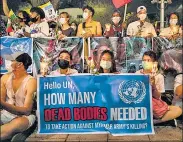  ??  ?? Anti-coup demonstrat­ors hold up banners during a protest outside the UN building in Bangkok, Thailand.