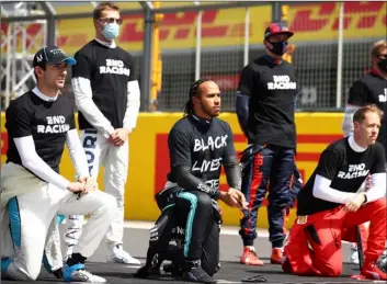  ?? Bryn Lennon/Pool via AP ?? Mercedes driver Lewis Hamilton of Britain (center) and other drivers rivers kneel during the anti-racism demonstrat­ion ahead of the British Formula One Grand Prix at the Silverston­e racetrack, Silverston­e, England, on Sunday 2020.