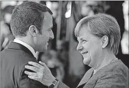  ?? [MICHAEL SOHN/THE ASSOCIATED PRESS] ?? New French President Emmanuel Macron is welcomed to Berlin by German Chancellor Angela Merkel on Monday, part of his first foreign trip since his inaugurati­on on Sunday.