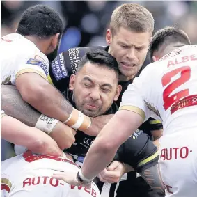  ?? Martin Rickett ?? Krisnan Inu finds his forward progress halted by a pack of Dragons players during Sunday’s clash at the Select Security Stadium.
