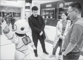  ?? PROVIDED TO CHINA DAILY ?? Visitors interact with a smart robot at a China Mobile booth during a high-tech exhibition in Guangzhou, capital of Guangdong province.