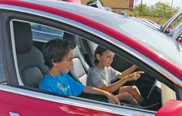  ?? ROBERT NOTT/THE NEW MEXICAN ?? Dylan Shandler, 9, in driver’s seat, and Noah Shandler, 12, pretend to test drive an electric car Saturday during a car show held at Santa Fe Place mall. ‘You don’t have to use gas,’ Noah said. ‘And they go really fast.’ He said he hopes to have his own when he’s old enough to drive.
