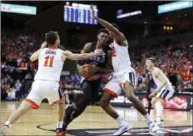  ?? ZACK WAJSGRAS — THE ASSOCIATED PRESS ?? Duke forward RJ Barrett (5) splits two Virginia defenders during the first half of an NCAA college basketball game Saturday in Charlottes­ville, Va.