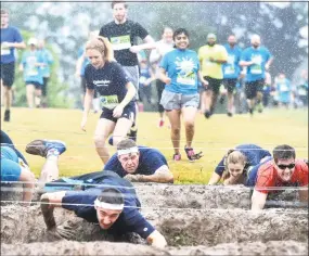  ?? Peter Hvizdak / Hearst Connecticu­t Media ?? Runners get down-and-dirty at the D-Day Obstacle during the Gaylord Hospital Gauntlet 5K Run Obstacle Course on Saturday.
