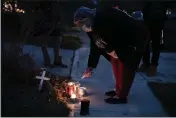  ?? JOSHUA A. BICKEL — THE COLUMBUS DISPATCH ?? A neighbor lights a candle Wednesday at a small memorial near the site of the fatal police shooting of Andre Hill on Oberlin Drive in Columbus, Ohio. Hill, 47, was shot and killed by Columbus Division of Police officer Adam Coy after responding to a suspicious vehicle call around 1:30 a.m., on Tuesday.