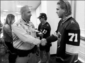  ?? ?? William Karlsson (71) offers his support to officers during the Knights’ visit to Metro. Behind him is teammate Brendan Leipsic (13).