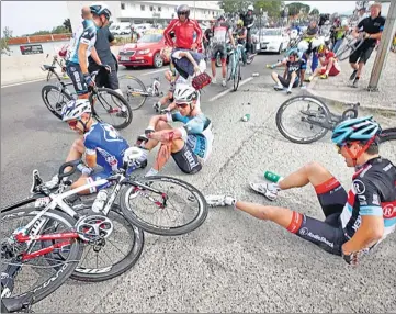  ?? REUTERS PHOTO ?? Tour de France competitor­s lie on the road after a crash on Saturday in Corsica.