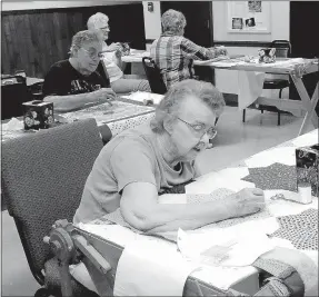  ?? Lynn Atkins/The Weekly Vista ?? Ann Brown is the only member of the Methodist Hand Quilters who uses the spoon method and avoids callouses on her fingers. In her case the spoon is really a butter knife that she holds under the fabric as she pushes her needle through. The group meets...