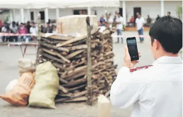  ?? — AFP photo ?? A Laos law enforcemen­t officer stand in front of piles of seized illegal drugs during a burning ceremony in Xam Neau town marking the Internatio­nal Day against Drug Abuse and Illicit Traffickin­g.