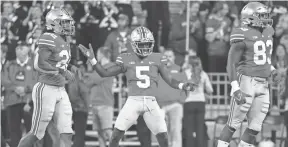  ?? JOSHUA A. BICKEL, ADAM CAIRNS/COLUMBUS DISPATCH ?? Left: Ohio State cornerback Marcus Williamson celebrates after Akron missed a field goal on Sept. 25. Right: K'vaughan Pope during this year's Ohio State spring game.