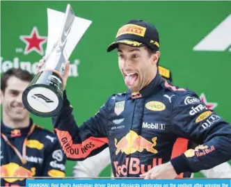  ??  ?? SHANGHAI: Red Bull’s Australian driver Daniel Ricciardo celebrates on the podium after winning the Formula One Chinese Grand Prix in Shanghai yesterday. — AFP