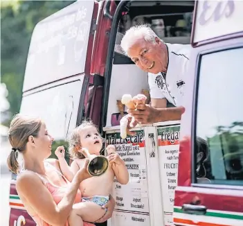  ?? FOTO: ANDREAS BRETZ ?? Salvatore Fregapane macht mit seinem roten Eismobil Halt an einem Spielplatz: Die kleine Emilia (2) freut sich nicht nur über ihr Vanille-Eis, sie durfte sogar einmal mit der großen Klingel des Eisverkäuf­ers läuten.