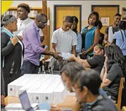  ?? BOB ANDRES / BANDRES@AJC.COM ?? Students at Cedar GroveHigh School in Ellenwood line up in themedia center where they received free internet hotspots as part of the Sprint 1Million Project.