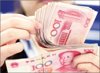  ??  ?? File photo shows a bank clerk counts Chinese 100 Yuan notes in Shanghai. China has tightened controls on trading in its yuan following a decline against the dollar that raised the risk of a damaging outflow of capital from the
world second-largest...