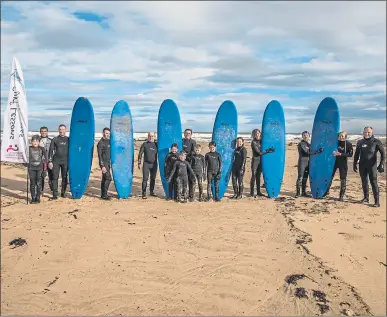  ??  ?? WAVES OF ENTHUSIASM: Members of Surfable Scotland on the beach at Lossiemout­h. The school also has a base in Sandend, Moray.