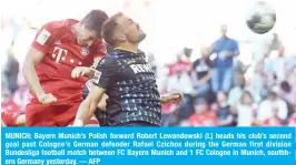  ?? — AFP ?? MUNICH: Bayern Munich’s Polish forward Robert Lewandowsk­i (L) heads his club’s second goal past Cologne’s German defender Rafael Czichos during the German first division Bundesliga football match between FC Bayern Munich and 1 FC Cologne in Munich, southhern Germany yesterday.