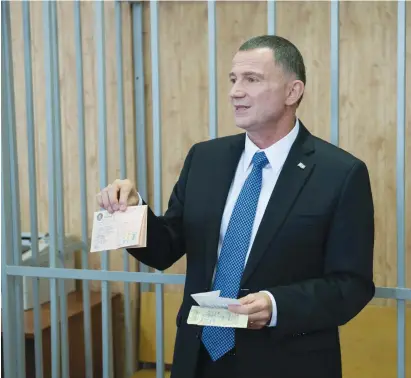  ?? (Courtesy Israeli Embassy, Moscow) ?? Jerusalem KNESSET SPEAKER Yuli Eldelstein holds his birth certificat­e and a union membership card, which were seized from him when he was jailed as a Prisoner of Zion 33 years ago.