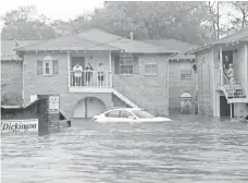  ?? KELSEY WALLING, AP ?? Residents in Dickinson, Texas, wait for help on Sunday.