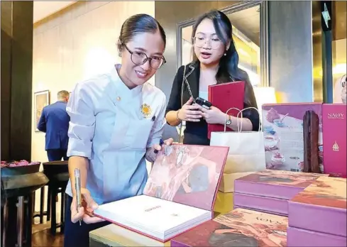  ?? HONG RAKSMEY ?? Chef Nak signs copies of her latest recipe book at the book launch event, held at Rosewood in Phnom Penh on May 12.