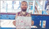  ?? JESCILIA KARAYAMPAR­AMBIL ?? Bosonogiy Maksimka with his placard at Bandra station on Wednesday.