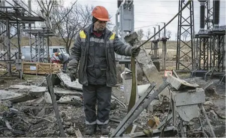  ?? ED RAM/GETTY ?? A worker repairs infrastruc­ture Friday at a power station in Kyiv, Ukraine, that was damaged in a Russian attack.