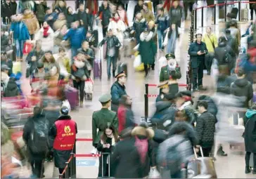  ?? FRED DUFOUR/AFP ?? A Chinese soldier (centre right) makes announceme­nts to travellers to respect the waiting halls at the West Railway Station in Beijing on February 10 ahead of the Lunar New Year.