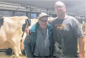  ??  ?? Farmers didn’t necessaril­y get that extra hour of sleep! Dad (Aurele Lefebvre) and my little brother Ronnie in the barn with the Holsteins last weekend.