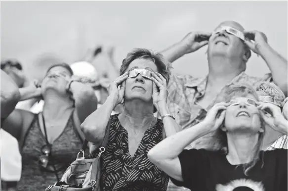  ?? HENRY TAYLOR, USA TODAY ?? Thousands look to the heavens in Charleston, S.C., as Monday’s total solar eclipse gave onlookers one last celestial thrill before it left the United States.
