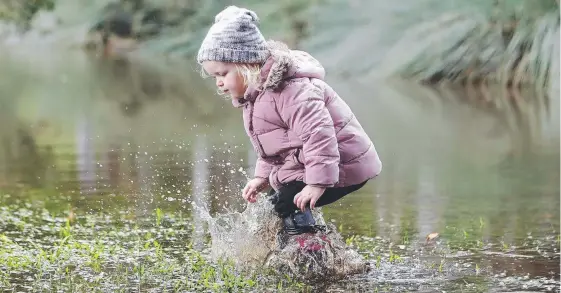  ?? Picture: RICHARD GOSLING ?? Poppy Shanahan finds the bright side in the clouds, jumping in a puddle at the Botanic Gardens in Benowa yesterday.