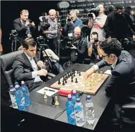  ?? FOTO: AP ?? El campeón Carlsen y el aspirante Caruana, rodeados de cámaras al inicio de la partida