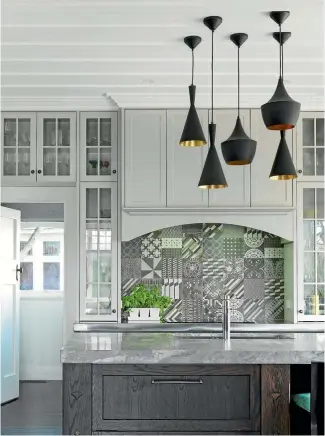  ??  ?? A cluster of pendant lights in different shapes enlivens this kitchen, and is one of the strongest looks at present.