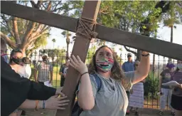  ?? MEG POTTER/THE REPUBLIC ?? Gracie Gardner carries a cross to the sixth station during the Stations of Cross in Phoenix on March 26.