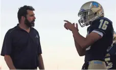  ?? LOGAN NEWMAN/ THE REPUBLIC ?? Phoenix Day School for the Deaf quarterbac­k Cesar Aranda talks to head coach Dave Huber on the sidelines during a game against Williams this month.