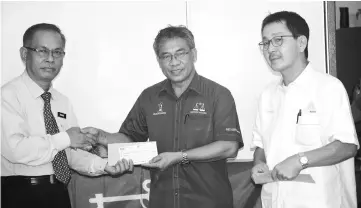  ??  ?? Nyabong (centre) presents a grant to SK Methodist Kapit headmaster Demang Sawing. Also seen is Kapit District Council Walikota Philimon Nuing.