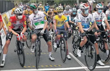  ??  ?? Los ciclistas esperan con la mascarilla puesta el inicio de la etapa de ayer en Niza.