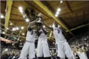  ?? MATT SLOCUM — THE ASSOCIATED PRESS ?? Villanova’s Josh Hart, from left, Darryl Reynolds and Kris Jenkins celebrate with the Big East conference regular season trophy after winning an NCAA college basketball game against Creighton, 79-63, Saturday in Villanova, Pa.