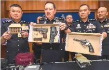  ?? — Bernama photo ?? Muhamad Zaki (centre) and his officers showing the firearms and bullets seized during the two raids.