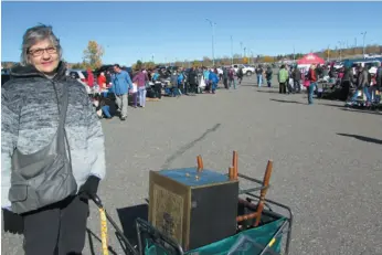  ?? CITIZEN PHOTO BY CHRISTINE HINZMANN ?? Susan Driedger of Vanderhoof pulled her many treasures behind her as she browsed through thousands of items available for sale during the Junk in the Trunk Sale held Saturday at CN Centre’s parking lot.