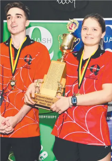  ??  ?? VICTORIOUS: Northern Redbacks squash captains Bradley Martin, from Townsville, and Courtney Mather, of Cairns, hold the trophy after defeating Brisbane in the 2018 State Teams Championsh­ips.