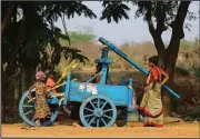  ?? (AP/Mahesh Kumar A.) ?? Indian children help a woman extract juice from sugar cane as she sells the sweetener along a road Tuesday on the outskirts of Hyderabad, India.