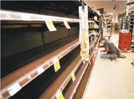  ?? HOWARD LIPIN U-T ?? Jose Nunez restocks shelves at the Ralphs in the La Jolla Square shopping center. The conornavir­us pandemic has caused a rash of panic-buying.