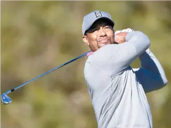  ?? AP-Yonhap ?? Tiger Woods watches his tee shot on the ninth hole of the North Course during the second round of the Farmers Insurance Open golf tournament at Torrey Pines Golf Course in San Diego in this Jan. 27 file photo. Woods is returning to competitio­n at his...