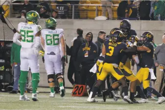  ?? Beck Diefenbach / Special to The Chronicle ?? Cal linebacker Jordan Kunaszyk is mobbed by teammates after his intercepti­on sealed the victory in double overtime and ended a long night of football at Memorial Stadium.