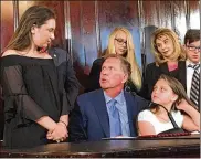  ?? LAURA A. BISCHOFF / COLUMBUS BUREAU ?? Ohio Gov. John Kasich signed Judy’s Law, which provides harsher penalties for attackers who disfigure or maim their victims. Judy Malinowski’s daughters, Kaylyn, 13, and Madison, 10, attended the signing ceremony.